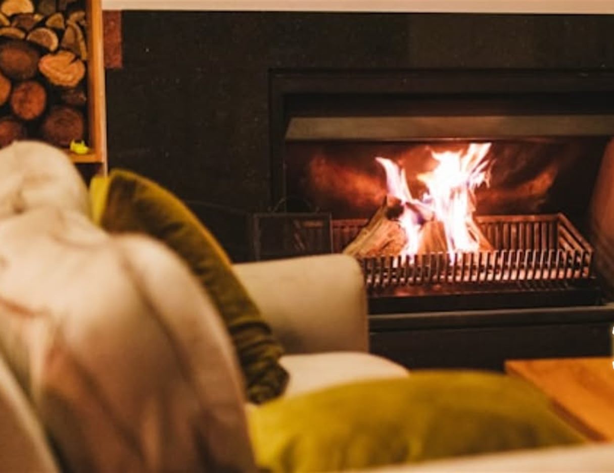 A lit fireplace insert burning in a furnished living room